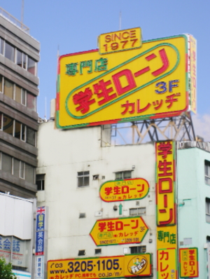 高田馬場駅前に目立つ学生ローン「カレッヂ」の看板・ビル